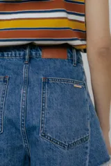 Short de jean azul oscuro, tiro alto, corte ancho y ruedo desflecado.