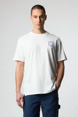 Remera blanca de algodón con cuello redondo y manga corta. Estampado en el pecho con un cuadrado lila y una "X" en el centro.