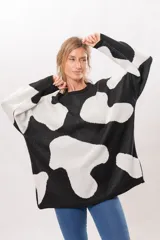 Buzo oversize de punto con estampado de manchas de vaca en blanco y negro.