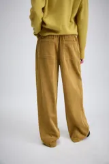 Pantalón de tiro medio confeccionado en tejido de pana, con diseño de pierna ancha, bolsillos delanteros y traseros, y cierre frontal con cremallera y botón.