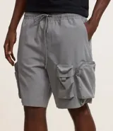 Bermuda cargo masculina de color gris, con cintura elástica ajustable mediante cordón. Presenta múltiples bolsillos tácticos con cierre y solapa, confeccionada en tejido plano de poliéster.