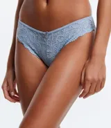 Bombacha de bikini de corte bikini, confeccionada en encaje floral azul claro. Presenta un borde festoneado y un pequeño lazo decorativo con dije en el centro frontal.