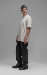 Remera de corte relajado con hombros caídos y silueta amplia, confeccionada en algodón premium. Presenta cuello redondo y mangas cortas, ofreciendo un calce cómodo y versátil.