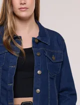 Campera de jean blanca de corte clásico, con cuello solapa, cierre frontal de botones metálicos y bolsillos aplicados con solapa en el pecho.