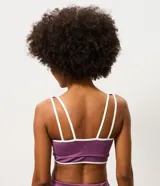 Top deportivo Get Over confeccionado en microfibra color violeta, con escote recto, copa incorporada, breteles anchos y bies contrastante en color blanco. Cuenta con banda acanalada en la base.