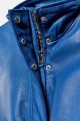 Cazadora bomber de cuero 100% color azul, con cuello alto, manga larga con puños con cremallera, bolsillos delanteros con solapa y bajo elástico. Cierre frontal con cremallera y botones a presión ocultos.