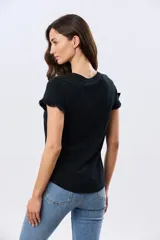 Remera de algodón color verde menta, con escote redondo y mangas corta con detalles de volados sutiles en los puños.