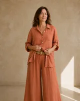 Camisa de lino color terracota, con mangas largas regulables, bolsillo ojal en el pecho, botones de nácar y corte holgado.