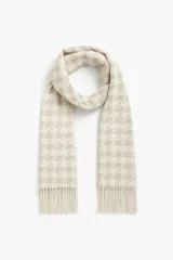 Bufanda rectangular color beige con estampado de pata de gallo en blanco y flecos en los extremos.