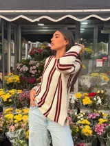Sweater de tejido de punto de algodón con diseño rayado en color blanco, bordó y rosado, cuello redondo a la base, mangas largas acampanadas y silueta oversize.
