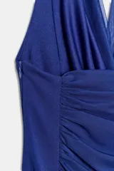 Vestido mini de cuello halter con escote drapeado, confeccionado con combinación de tejidos y detalle de frunces en el frente. Cuenta con forro interior y cierre lateral con cremallera oculta.