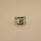 Anillo ancho de diseño bicolor, con bandas laterales en oro y una franja central de plata con textura escarchada. Presenta una circonia central de corte ovalado engastada en el centro.