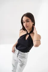 Top negro brillante con escote halter y espalda descubierta.