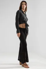 Camisa negra de manga larga con lazo en la cintura y botones nacarados.