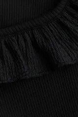 Musculosa corta negra de ajuste entallado en punto acanalado de algodón. Modelo con breteles y escote cuadrado con ribete de volado efecto arrugado que se prolonga por los hombros.