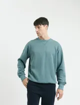 Sweater básico de cuello redondo y manga larga, confeccionado en tejido circular con puños y cuello en tejido canalé.