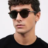 Lentes de sol unisex con armazón geométrico color carey y lentes polarizadas color verde oscuro.