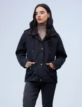 Campera azul marino liviana marca Michael Kors, con capucha escondida en el cuello, cierre oculto con botones a presión, bolsillos delanteros y avíos metálicos dorados con logo.