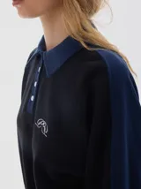 Buzo de friza suave color azul marino, con cuello polo y cartera de botones en contraste azul denim. Mangas raglán con franjas laterales azules y logo bordado en el pecho.