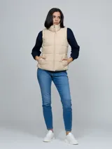Chaleco acolchado de cuello alto con cierre frontal de cremallera y dos bolsillos laterales de ojal. Presenta un diseño moderno y ligero, con detalles distintivos de la marca.