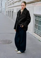 Pantalón de jean estilo barrel con diseño balloon, de tiro medio y corte holgado. Presenta cinco bolsillos, cierre frontal con cremallera y botón, y costuras en contraste.