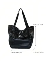 Bolso tote negro de cuero sintético con diseño holgado y dos asas de hombro. Presenta tachas metálicas redondas plateadas cubriendo la parte superior del cuerpo del bolso.