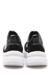 Zapatillas deportivas negras de cuero con cierre dorado en el empeine y suela blanca.