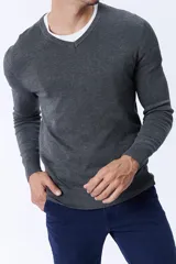 Buzo de punto gris melange con escote en V, de manga larga y puños acanalados.