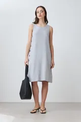 Vestido gris melange de lino, corte recto, sin mangas y con botones decorativos en el lateral.