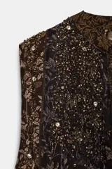Top sin mangas de Zara Woman Collection, confeccionado en viscosa con diseño patchwork de estampados florales en tonos marrones y negros. Presenta cuello redondo con detalle de abalorios bordados en la parte superior y cierre posterior con botones.