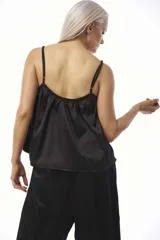 Musculosa de satén color negro, de corte holgado, con tirantes finos y escote fruncido ajustable con cordón.
