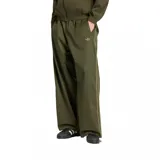 Pantalón deportivo Adidas de corte ancho y relajado, color verde militar con cintura elástica y las clásicas tres tiras a los lados en tono más claro. Presenta el logo del trifolio bordado discretamente en la parte delantera.