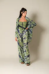 Pantalón de pierna ancha con estampado tipo tie-dye en tonos verde oliva y azul oscuro. La prenda es de malla y tiene cintura ajustable.