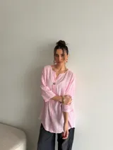 Blusa de viscosa de corte holgado, color rosado con sutil textura a cuadros, escote en V y cierre frontal con un botón.