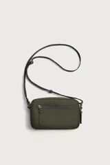 Bandolera porta teléfono de acabado engomado en color verde militar. Cuenta con un compartimento principal y un bolsillo frontal con cierre de cremallera, además de un bolsillo interior también con cierre. Incluye asa de hombro ajustable y extraíble, y detalle de mosquetón en el lateral.