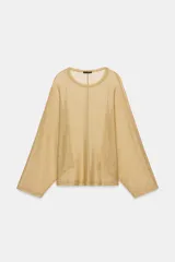 Top de cuello redondo y manga larga, confeccionado en tejido ligero con hilo metalizado de acabado dorado, con bajo recto y diseño holgado.