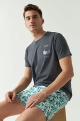 Short de baño con estampado botánico en tonos turquesa, blanco y azul. Presenta cintura elástica con cordón ajustable, dos bolsillos laterales y uno trasero, además de un logo bordado en la pierna.