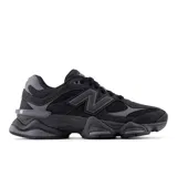 Championes urbanos New Balance modelo 9060, color negro con detalles en gris oscuro. Presentan un diseño robusto y futurista inspirado en la estética Y2K, confeccionados con parte superior de malla y superposiciones de gamuza, entresuela gruesa con amortiguación y suela texturizada.