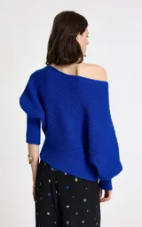 Sweater de punto color azul eléctrico con diseño de hombro caído y escote asimétrico. Presenta textura acanalada, mangas largas con ligero volumen y puños ajustados de canalé.
