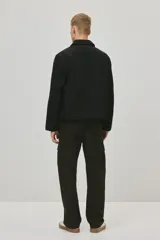 Pantalón cargo de sarga de algodón en color verde militar, con corte regular fit, múltiples bolsillos laterales con solapa y cierre de botón a presión.