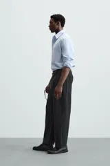 Camisa de manga larga color celeste claro, corte regular fit, con cuello solapa, bolsillo plastrón en el pecho y cierre frontal de botonadura.