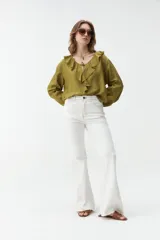 Jean flare de color blanco con costuras en contraste y diseño de tiro medio.