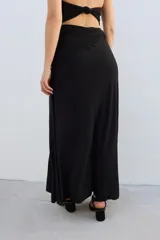 Falda larga de tejido brillante color azul con detalle de nudo en la cintura.