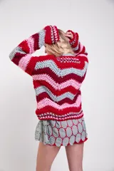 Sweater tejido a crochet de lana merino con diseño de rayas en zigzag de colores, cuello redondo, mangas largas amplias y calce holgado.