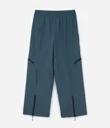 Pantalón de corte holgado en color azul petróleo, confeccionado en microfibra de poliéster. Presenta un diseño utilitario con múltiples bolsillos funcionales, cierres visibles y detalles técnicos en las piernas.