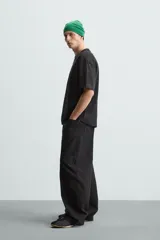 Camiseta color arena de algodón compacto, corte recto, cuello redondo y mangas cortas.