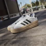 Championes adidas VL Court Bold con diseño de plataforma, capellada de cuero sintético blanco, las icónicas tres tiras laterales en negro y suela de goma color caramelo.