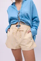 Short blanco de lino y algodón, con cintura elastizada y cordón ajustable.