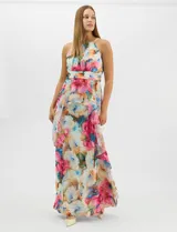 Vestido largo de chifón con estampado floral multicolor. Presenta cuello halter con plisado en el pecho, cintura drapeada y falda amplia con capas asimétricas que aportan movimiento. Incluye forro interior y cierre invisible en la espalda.