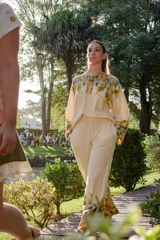 Conjunto de dos piezas confeccionado en lana merino, compuesto por un buzo de corte holgado con mangas acampanadas y un pantalón de pierna ancha con cintura elastizada y bolsillos laterales. Ambas prendas presentan un diseño artesanal con técnica de ecoprint en tonos tierra y azulados sobre base color crema.